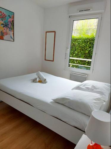 un lit blanc dans une chambre avec une fenêtre dans l'établissement Vaillant Couturier - Lyon 2 - LB Quiet and bright with terrace and private parking, à Vénissieux