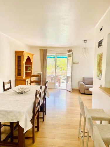 une salle à manger avec une table et des chaises blanches dans l'établissement La Maison d'Apolline, à Sahune