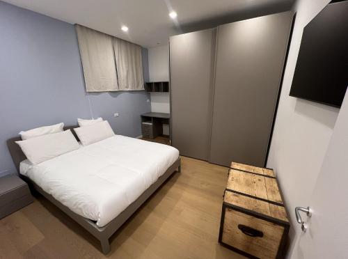 a small bedroom with a white bed and a table at Luxury Apartment, Downtown IMOLA, Italy in Imola