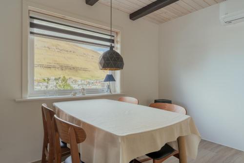 a dining room with a white table and chairs at 2BR House with Scenic Views - Parking - Klaksvík in Klaksvík