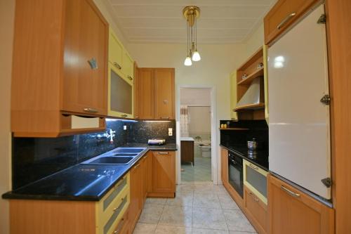 a kitchen with wooden cabinets and black counter tops at Astraea 7 in Hydra