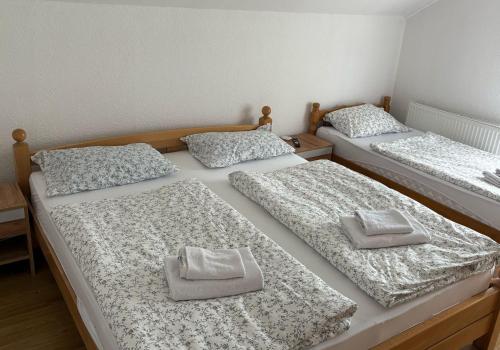 3 camas con almohadas en una habitación en Apartmani D&D, en Jajce