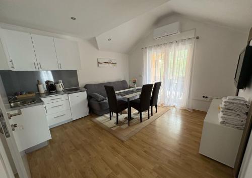 Una cocina y un comedor con mesa y sillas. en Apartmani D&D, en Jajce