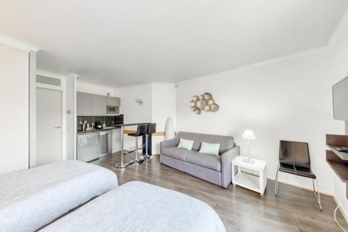 un salon avec deux lits et un canapé dans l'établissement 7mn walk to Metro, in ApartHotel, à Courbevoie