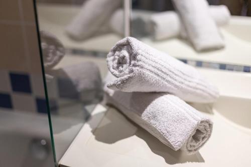 une pile de serviettes blanches assises sur un comptoir dans l'établissement 7mn walk to Metro, in ApartHotel, à Courbevoie