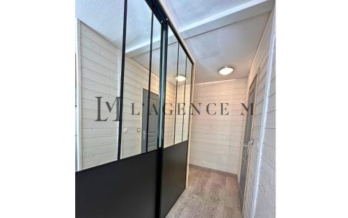 un couloir avec des portes vitrées et un panneau sur le mur dans l'établissement Studio Casa Vecchia, à Calvi