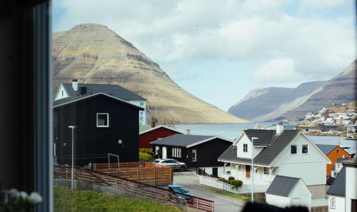 a view of a town with a mountain in the background at 2BR House with Scenic Views - Parking - Klaksvík in Klaksvík