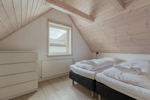 two beds in a attic bedroom with a window at 2BR House with Scenic Views - Parking - Klaksvík in Klaksvík