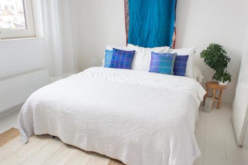a bedroom with a white bed with blue pillows at Lovely cozy houseboat Rembrandt, old centre Leiden in Leiden