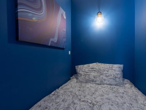 une chambre bleue avec un lit dans un mur bleu dans l'établissement Cosy et design Villeurbanne centre, à Villeurbanne