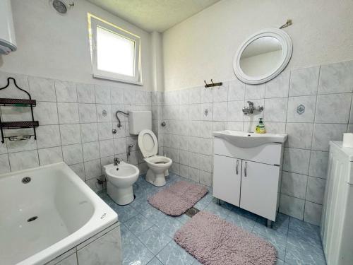 a bathroom with a sink and a toilet and a tub at Rest House in Olovo