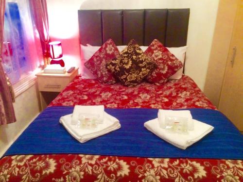 a bed with two plates and two glasses on it at Metro Star in London