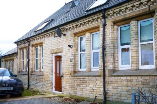 a brick house with a car parked in front of it at Modern Comfort in a Beautiful Location - No3 Rosedene Mews in Marske-by-the-Sea
