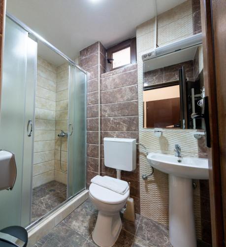 a bathroom with a toilet and a sink and a shower at Konaci Manastir Sveti Stefan - Ohrid in Ohrid
