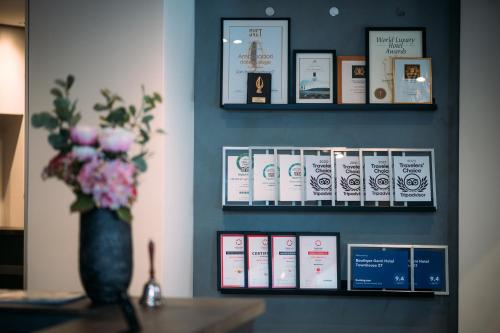 a shelf with books on a wall with a vase of flowers at Boutique Hotel Townhouse 27 in Belgrade