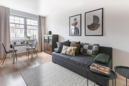 una sala de estar con un sofá y una mesa en Klimatyczny apartament 3-pokojowy, en Olsztyn