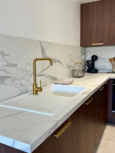 - une cuisine avec un évier et un comptoir en marbre dans l'établissement Appartement neuf contemporain, à Lourdes