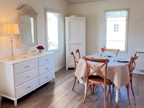 une salle à manger avec une table, des chaises et une commode dans l'établissement 138 - Roses des Sables Ocean View Full Village Center, à Saint-Martin-de-Ré