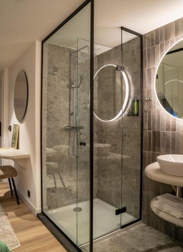 a glass shower in a bathroom with a sink at Boutique Hotel Annamaes, Maastricht-Hoge Kempen in Lanaken