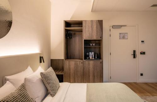 a bedroom with a bed with white sheets and pillows at Boutique Hotel Annamaes, Maastricht-Hoge Kempen in Lanaken