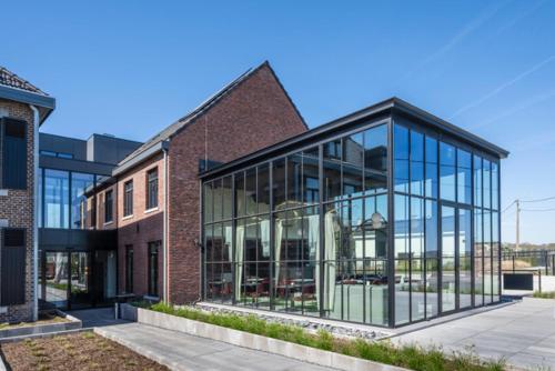 a brick building with glass windows on a street at Boutique Hotel Annamaes, Maastricht-Hoge Kempen in Lanaken