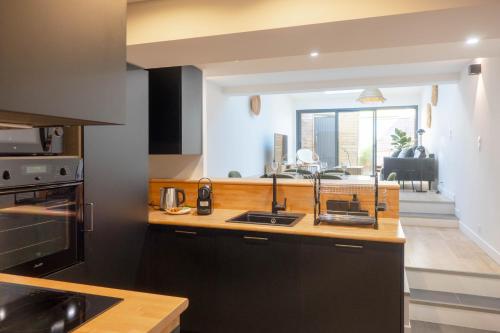une cuisine avec un évier et un plan de travail dans l'établissement La Maison Scandi-Loire - 3 chambres avec Garage, à Orléans