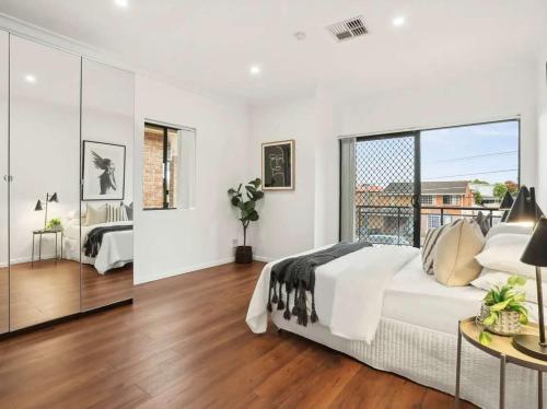 a bedroom with a large bed and a large window at Luxury house hotel Lidcombe Sydeny Australia in Rookwood Station