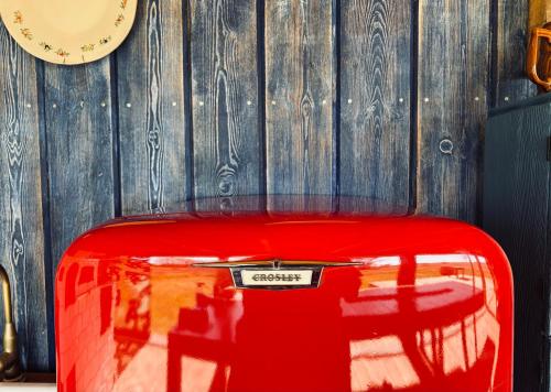 a red suitcase sitting in front of a wall with a clock at dla mnie się podoba in Krzywiec
