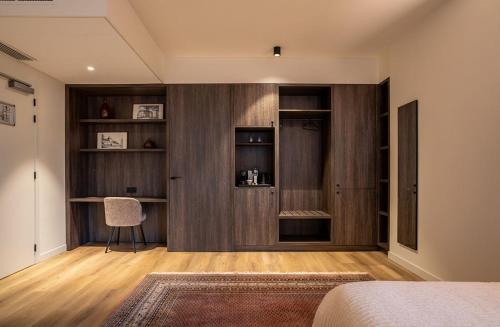 a bedroom with wood paneling and a chair in a room at Boutique Hotel Annamaes, Maastricht-Hoge Kempen in Lanaken