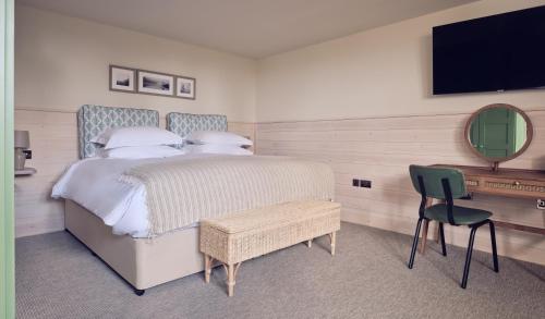 a bedroom with a bed and a desk with a television at The Fish Hotel in Broadway