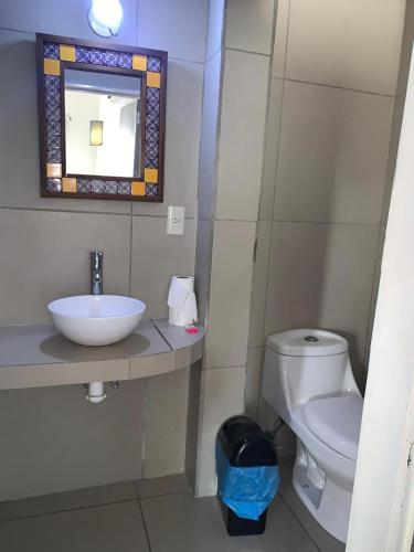 a bathroom with a sink and a toilet and a mirror at hotel las olas zicatela 2 in Brisas de Zicatela