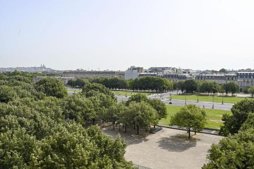 - une vue sur un parc arboré et des bâtiments dans l'établissement Bright Penthouse with Panoramic Views Invalides, à Paris