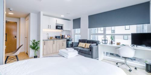 a bedroom with a white bed and a living room at City Studios, Preston in Preston