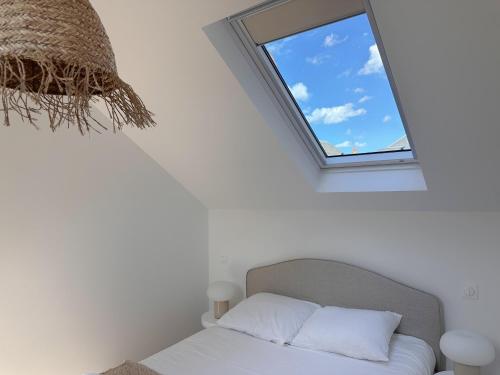 a bed in a white room with a window at La Maison Scandi-Loire Classée 3 étoiles à ORLEANS en bord de Loire - 3 chambres avec Garage in Orléans