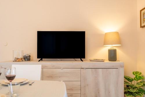 a flat screen tv sitting on top of a wooden entertainment center at Zafferana's Pool Retreat in Zafferana Etnea