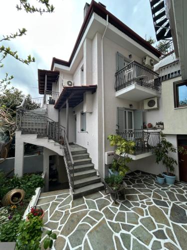 a white house with stairs and a patio at Guesthouse Doma est 1991 in Arachova