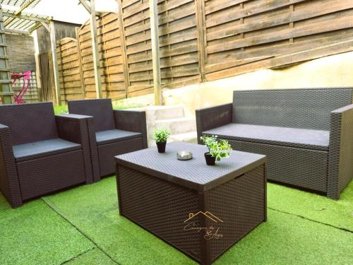 a patio with two chairs and a table on grass at Maison cosy avec jardin privé proche gare in Le Mans