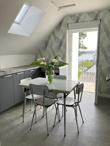 une salle à manger avec une table et des chaises et une fenêtre dans l'établissement Appartement à St Cado sur la Ria, à Belz