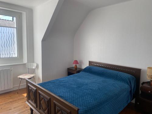 une chambre avec un lit avec une couette bleue et une fenêtre dans l'établissement Appartement à St Cado sur la Ria, à Belz