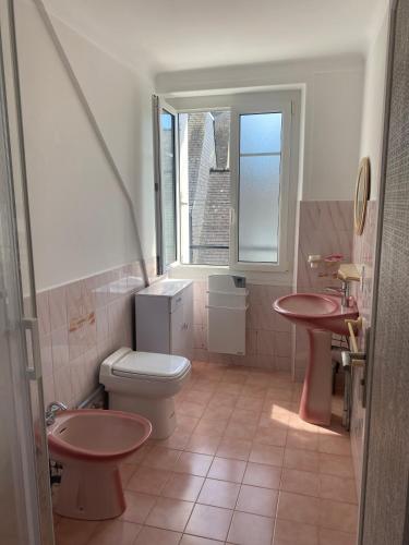 La salle de bains est pourvue de toilettes, de 2 lavabos et d'une fenêtre. dans l'établissement Appartement à St Cado sur la Ria, à Belz