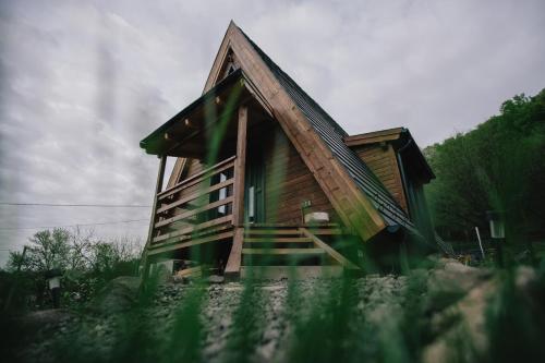 a small wooden house with a staircase in front at MátraTea Elvonulóház in Parád