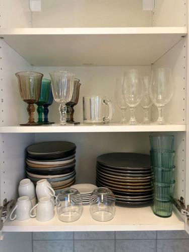 a cupboard filled with plates and glasses and dishes at La Maison du Lac in Bissone