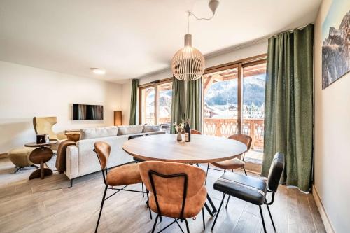 un salon avec une table, des chaises et un canapé dans l'établissement La Terrasse de Nyon Magnifique T4 cabine au centre du village, à Morzine