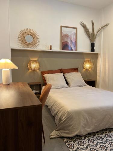 - une chambre avec un lit et un bureau avec deux lampes dans l'établissement Appartement Nice proche centre-ville, à Nice