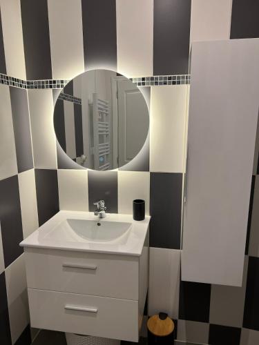 une salle de bain avec un lavabo et un miroir dans l'établissement Appartement Nice proche centre-ville, à Nice