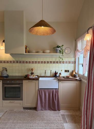 - une cuisine avec un évier et une lumière dans l'établissement Chateau de Pomiro chambres d'hôtes et gîte, à Montréal