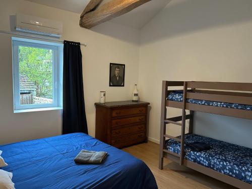 a bedroom with a bunk bed and a window at La Magnanerie de l'Estrade, gîte 8 pers avec piscine in Rosières