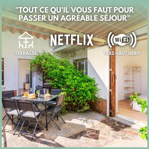 un patio avec une table et des chaises devant une maison dans l'établissement Le Pré Vert - Terrasse - Calme - Netflix, au Mans