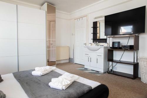 a bedroom with a bed and a sink and a bathroom at 5bed house town centre location up to 10 guests in Eastbourne