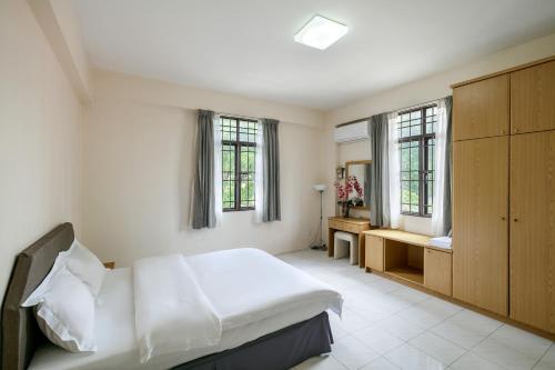 ein Schlafzimmer mit einem Bett und ein Bad mit Fenstern in der Unterkunft 3-Bedroom Stay at Macalister Road & Georgetown, Noble Villa Penang in George Town
